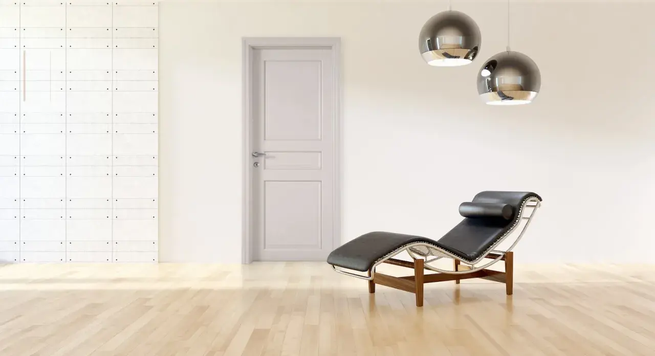 Divano in pelle nera e metallo, con un'elegante porta tortora e un muro con texture geometrica. Un perfetto abbinamento tortora e verde per un ambiente moderno.