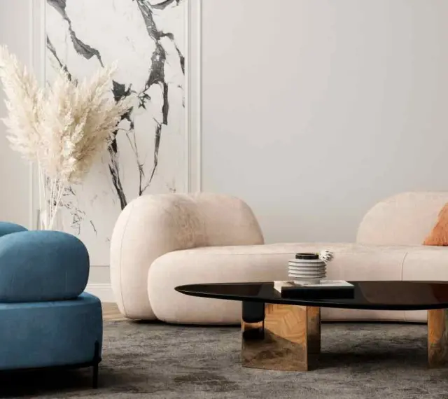 Un divano beige dalle forme morbide crea un'atmosfera accogliente, con abbinamenti di cuscini in terracotta e blu.