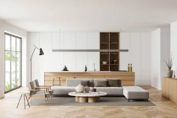 Soggiorno e cucina open space con mobili contemporanei moderni, divano, tavolino e isola.