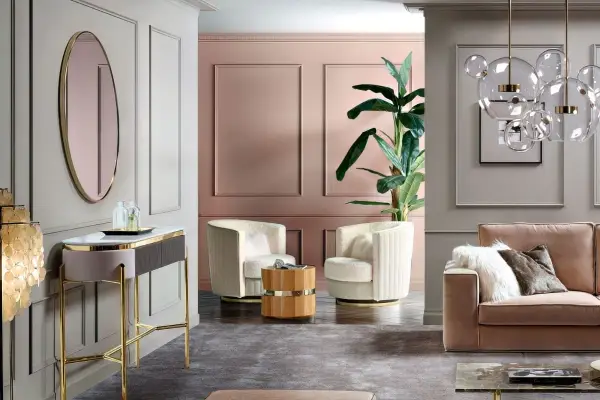 Un salotto elegante con pareti rosa antico e oro, divano in velluto, poltrone soffici e un tavolino in legno.