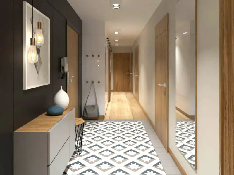 Un corridoio stretto con un tappeto geometrico, mobili moderni e un quadro astratto. Idee per un corridoio che unisce funzionalità ed estetica.